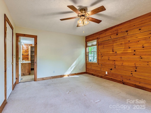 287 Sara Ridge Rd, Waynesville, NC 28786 - carpeted empty room with a textured ceiling, wooden walls, a ceiling fan, and baseboards