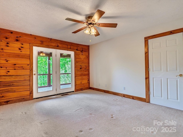 287 Sara Ridge Rd, Waynesville, NC 28786 - carpeted spare room with wood walls, a ceiling fan, baseboards, and a textured ceiling