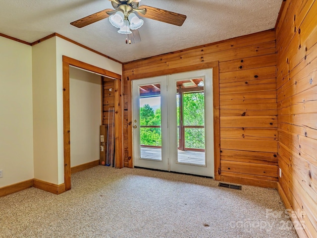 287 Sara Ridge Rd, Waynesville, NC 28786 - carpeted empty room featuring ornamental molding, wooden walls, ceiling fan, baseboards, and a textured ceiling