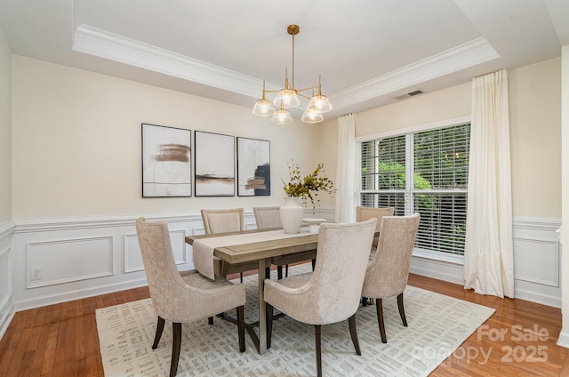 2504 Korbel Ct, Waxhaw, NC 28173 - dining space with a tray ceiling, ornamental molding, wood finished floors, a wainscoted wall, and a decorative wall