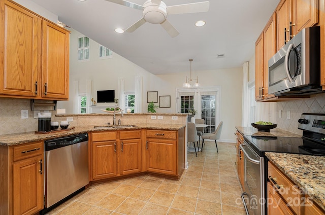 2504 Korbel Ct, Waxhaw, NC 28173 - kitchen with appliances with stainless steel finishes, a peninsula, tasteful backsplash, a ceiling fan, and light stone countertops