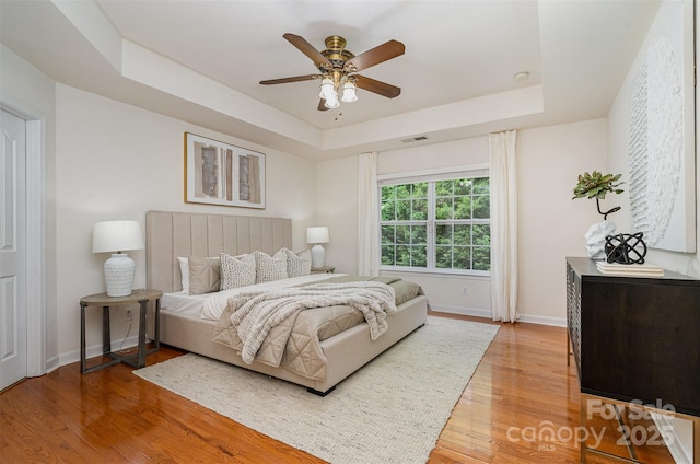 2504 Korbel Ct, Waxhaw, NC 28173 - bedroom featuring a raised ceiling, light wood-style flooring, and a ceiling fan