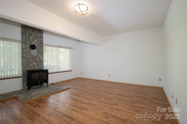 1 Spring Rd, Spruce Pine, NC 28777 - unfurnished living room with wood finished floors, a wood stove, and baseboards