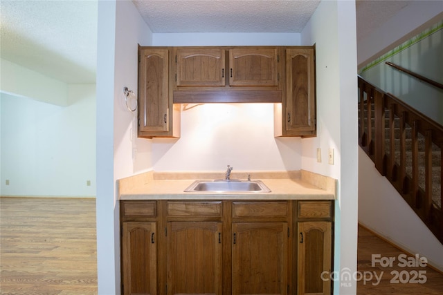 1 Spring Rd, Spruce Pine, NC 28777 - kitchen with a sink, light countertops, a textured ceiling, light wood-style floors, and brown cabinetry