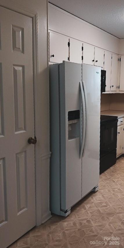617 College Ave SW, Lenoir, NC 28645 - kitchen with stainless steel fridge, range, light flooring, white cabinets, and a textured ceiling