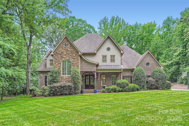 1056 James Madison Dr, Matthews, NC 28104 - view of front of home featuring a front lawn, a shingled roof, stone siding, a standing seam roof, and brick siding