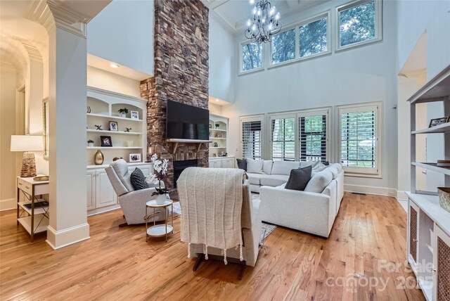 1056 James Madison Dr, Matthews, NC 28104 - living area with a towering ceiling, light wood finished floors, baseboards, healthy amount of natural light, and a stone fireplace