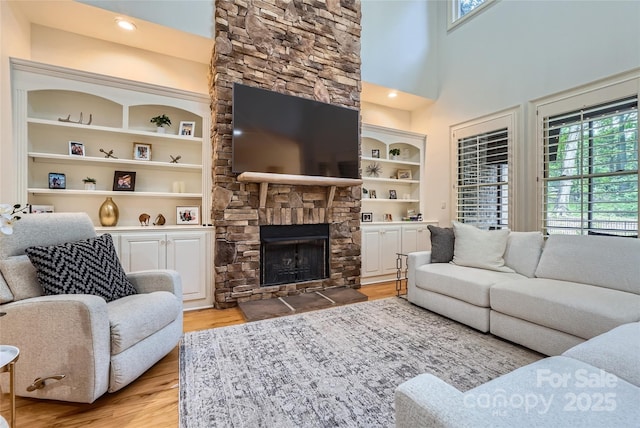 1056 James Madison Dr, Matthews, NC 28104 - living area featuring plenty of natural light, light wood-type flooring, a fireplace, and built in features