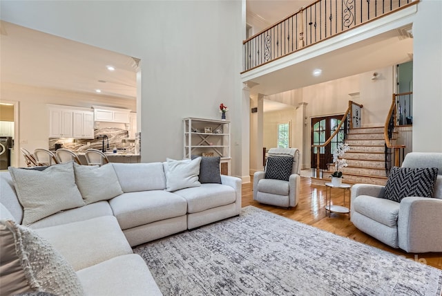 1056 James Madison Dr, Matthews, NC 28104 - living area featuring wood finished floors, a high ceiling, stairs, and recessed lighting