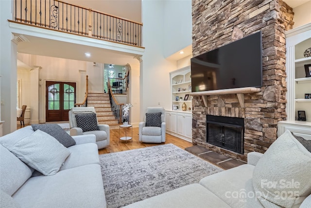 1056 James Madison Dr, Matthews, NC 28104 - living area with wood finished floors, stairway, a fireplace, baseboards, and a high ceiling