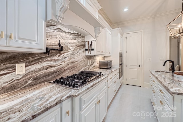 1056 James Madison Dr, Matthews, NC 28104 - kitchen featuring a sink, stainless steel appliances, decorative backsplash, white cabinets, and ornamental molding