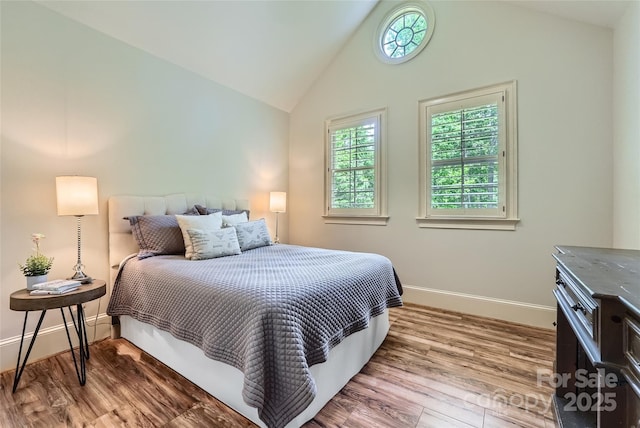 1056 James Madison Dr, Matthews, NC 28104 - bedroom featuring vaulted ceiling, baseboards, and wood finished floors