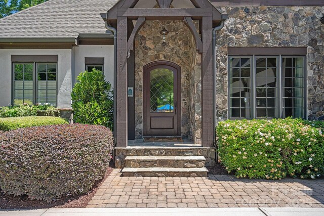 18718 Peninsula Cove Ln, Cornelius, NC 28031 - property entrance featuring stone siding, a shingled roof, and stucco siding