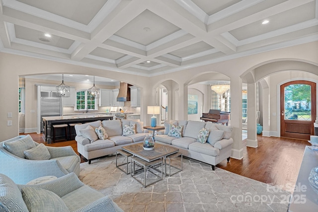 18718 Peninsula Cove Ln, Cornelius, NC 28031 - living room featuring arched walkways, light wood-style floors, a chandelier, plenty of natural light, and beamed ceiling