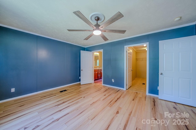 4065 NC-126 Hwy, Morganton, NC 28655 - unfurnished bedroom with ornamental molding, wood finished floors, a walk in closet, a decorative wall, and baseboards