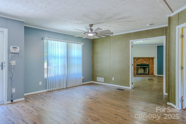 4065 NC-126 Hwy, Morganton, NC 28655 - spare room featuring wood finished floors, a textured ceiling, ornamental molding, ceiling fan, and a brick fireplace