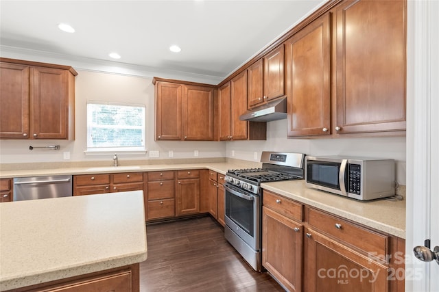 4352 Haddington Dr, Fort Mill, SC 29707 - kitchen featuring appliances with stainless steel finishes, under cabinet range hood, a sink, brown cabinets, and dark wood-style flooring
