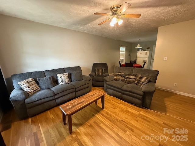 405 Jose St, Shelby, NC 28150 - living room featuring light wood-type flooring, a textured ceiling, a ceiling fan, and baseboards