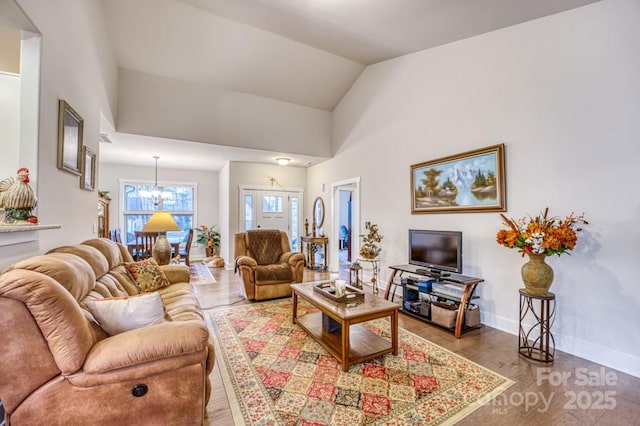 153 Water Leaf Dr, Weaverville, NC 28787 - living room featuring a chandelier, wood finished floors, baseboards, and lofted ceiling