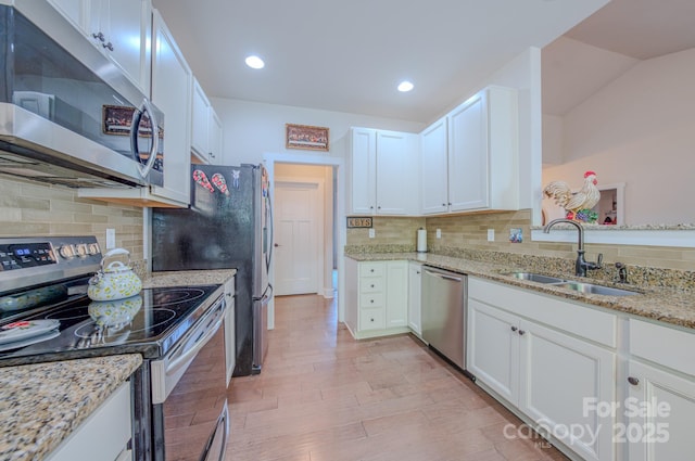 153 Water Leaf Dr, Weaverville, NC 28787 - kitchen with stainless steel appliances, a sink, backsplash, white cabinetry, and light stone countertops