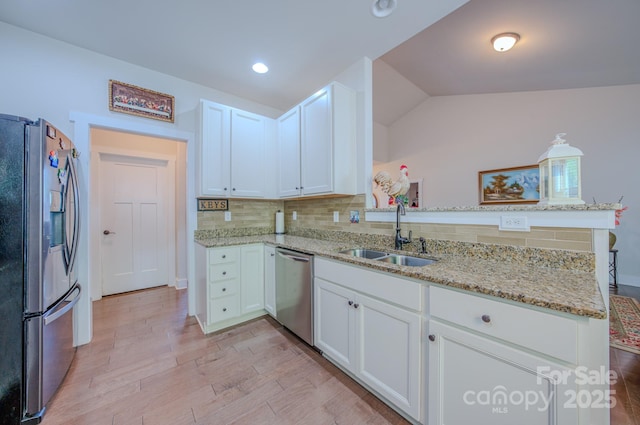 153 Water Leaf Dr, Weaverville, NC 28787 - kitchen with appliances with stainless steel finishes, a sink, white cabinets, a peninsula, and vaulted ceiling