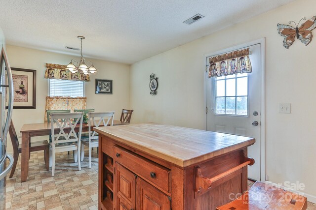 6079 Little River Ct, Granite Falls, NC 28630 - kitchen with wooden counters, a chandelier, decorative light fixtures, brown cabinets, and a textured ceiling