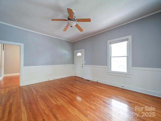 318 Chestnut Ave, Kannapolis, NC 28081 - spare room with wood finished floors, a wainscoted wall, ceiling fan, crown molding, and a textured ceiling