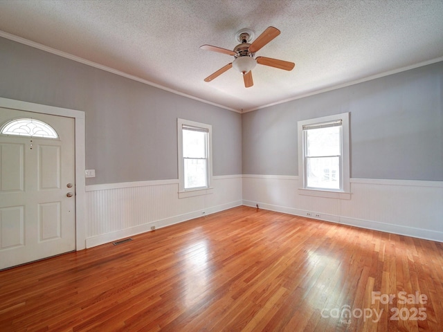 318 Chestnut Ave, Kannapolis, NC 28081 - entryway with light wood finished floors, wainscoting, a ceiling fan, ornamental molding, and a textured ceiling