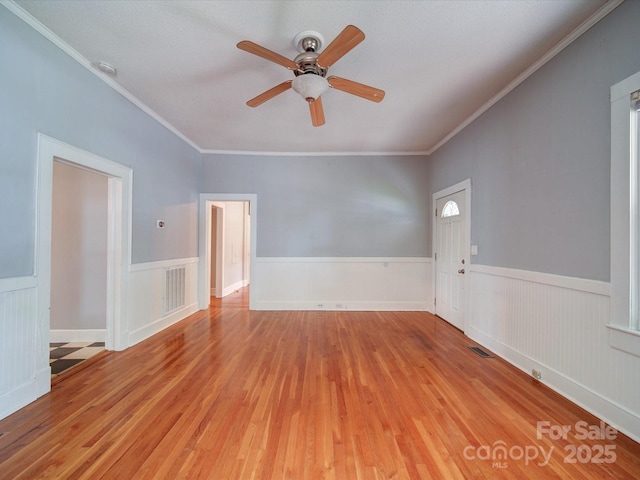 318 Chestnut Ave, Kannapolis, NC 28081 - unfurnished room featuring wood finished floors, a ceiling fan, wainscoting, crown molding, and a smoke detector