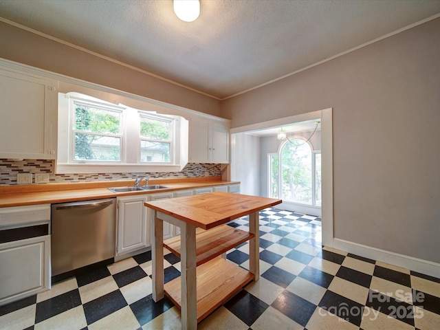 318 Chestnut Ave, Kannapolis, NC 28081 - kitchen featuring stainless steel dishwasher, light flooring, tasteful backsplash, white cabinetry, and crown molding