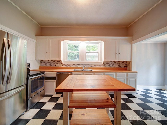 318 Chestnut Ave, Kannapolis, NC 28081 - kitchen with appliances with stainless steel finishes, light floors, white cabinets, backsplash, and ornamental molding