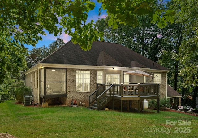 171 Secretariat Dr, Mooresville, NC 28117 - back of house at dusk featuring a deck, a yard, and brick siding