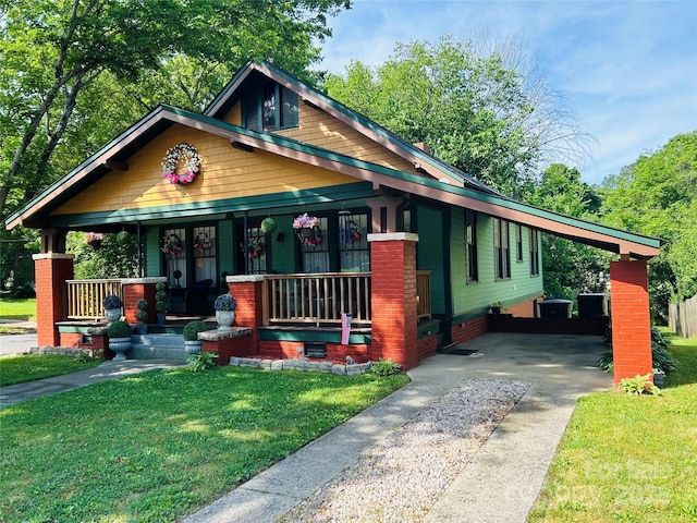 401 7th St, Spencer, NC 28159 - view of front facade featuring a porch, concrete driveway, a front yard, and a carport