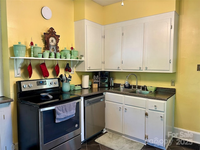 401 7th St, Spencer, NC 28159 - kitchen featuring stainless steel appliances, a sink, dark countertops, and white cabinetry