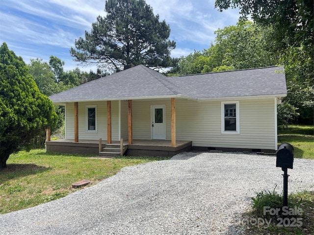 view of front facade featuring roof with shingles, a porch, driveway, and crawl space
