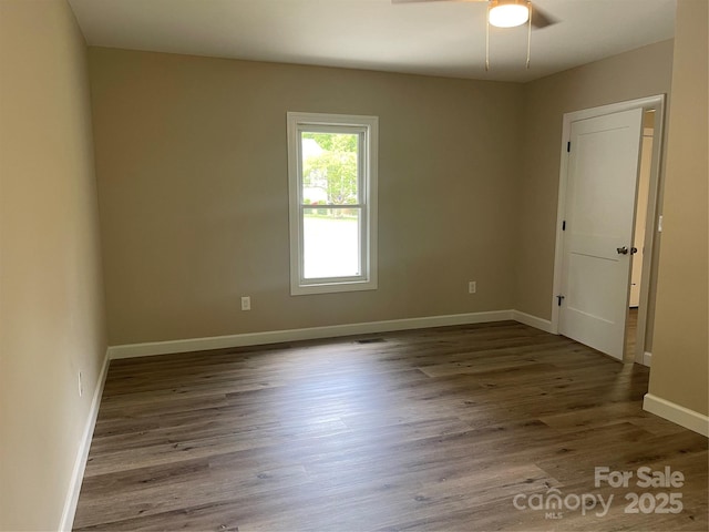 spare room with ceiling fan, wood finished floors, and baseboards