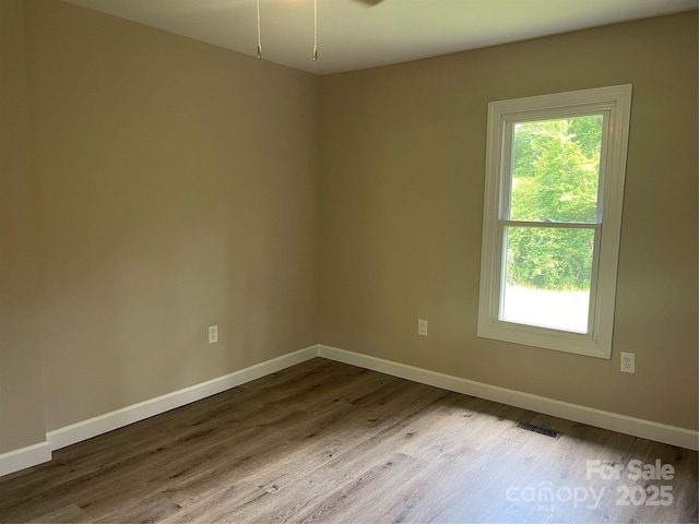empty room featuring dark wood finished floors and baseboards