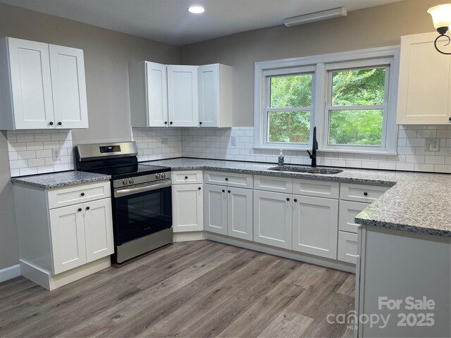 1327 Wiscassett St, Albemarle, NC 28001 - kitchen featuring stainless steel range with electric cooktop, a sink, light wood-style floors, white cabinets, and recessed lighting