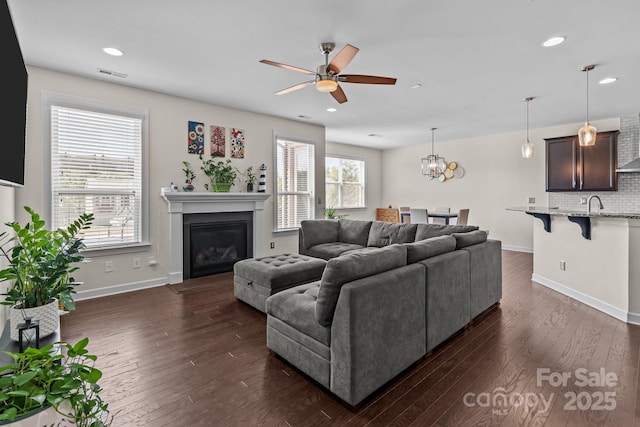 2835 Berkhamstead Cir, Concord, NC 28027 - living area with ceiling fan, dark wood-style flooring, a glass covered fireplace, baseboards, and recessed lighting