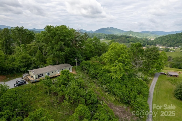 view from above of property featuring a mountainous background and a forest