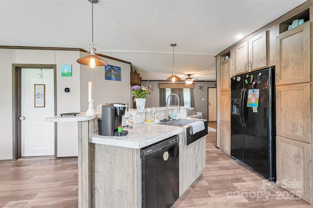 kitchen with black appliances, a sink, light wood finished floors, and light countertops