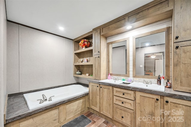 full bath featuring a garden tub, wood finished floors, and double vanity