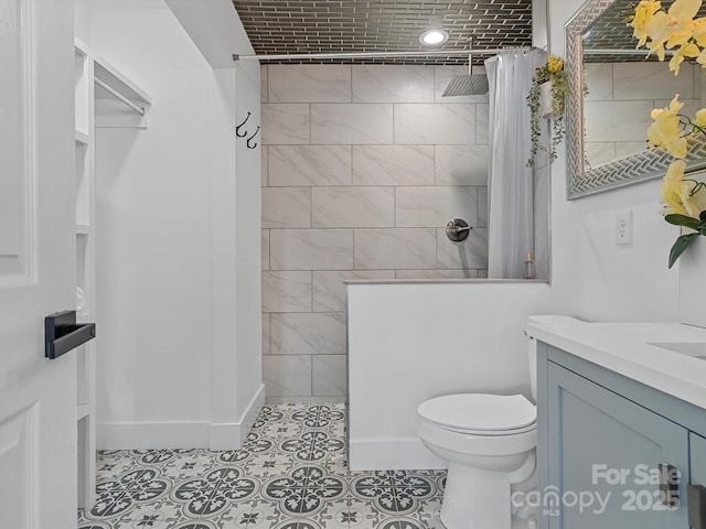 bathroom with walk in shower, toilet, tile patterned flooring, vanity, and baseboards