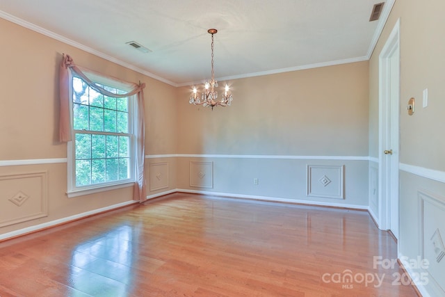 466 Shiloh Church Rd, Hickory, NC 28601 - unfurnished room featuring wood finished floors, a chandelier, a decorative wall, crown molding, and a wainscoted wall