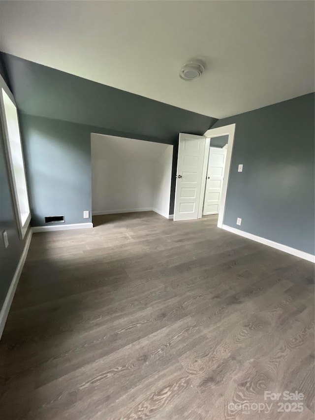 836 Mccreary St, Winston Salem, NC 27105 - unfurnished bedroom featuring vaulted ceiling, baseboards, and wood finished floors