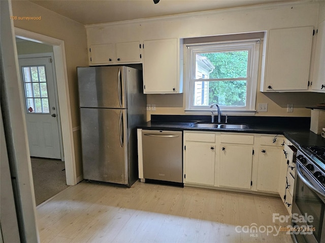 7608 Surreywood Pl, Charlotte, NC 28270 - kitchen with stainless steel appliances, a sink, light wood-style flooring, dark countertops, and white cabinetry