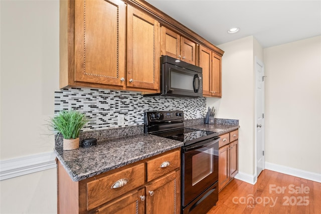8717 Swift Rd, Oakboro, NC 28129 - kitchen featuring black appliances, brown cabinets, decorative backsplash, light wood-style floors, and baseboards