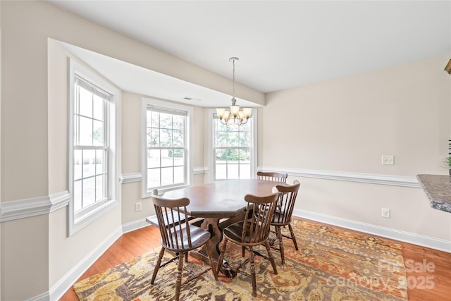 8717 Swift Rd, Oakboro, NC 28129 - dining area with light wood-type flooring, healthy amount of natural light, baseboards, and a chandelier
