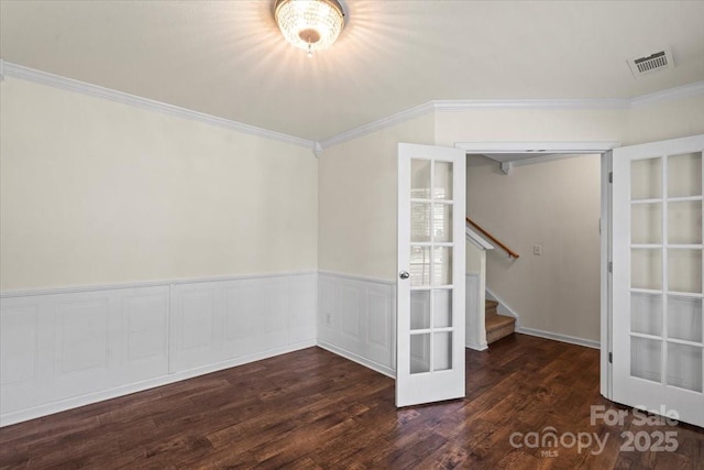 2515 Walnut Forest Dr, Charlotte, NC 28216 - empty room with ornamental molding, wood finished floors, stairs, a wainscoted wall, and french doors