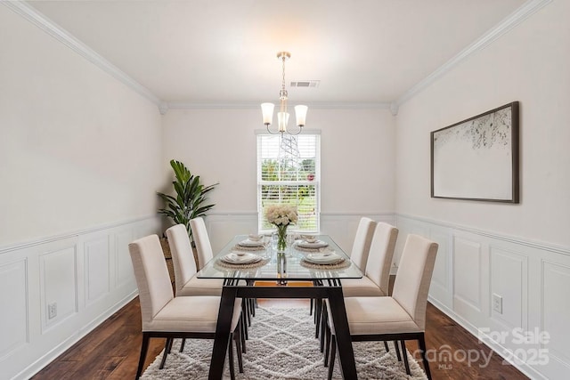 2515 Walnut Forest Dr, Charlotte, NC 28216 - dining area with a chandelier, crown molding, wainscoting, dark wood-style flooring, and a decorative wall